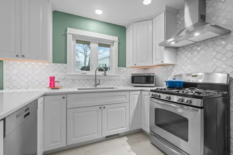 a kitchen with white cabinets and appliances
