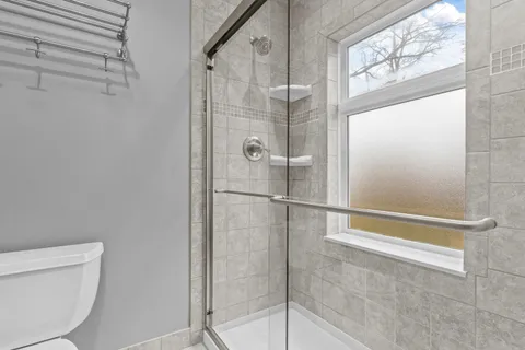 a bathroom with a granite countertop shower and a toilet
