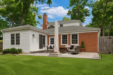 a backyard of a house with yard table and chairs