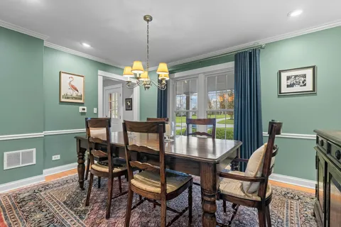 a dining room with furniture a chandelier and wooden floor