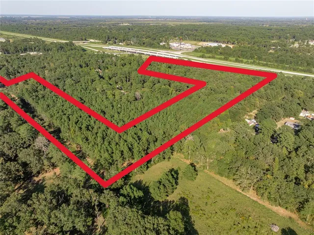 an aerial view of residential houses with outdoor space and trees
