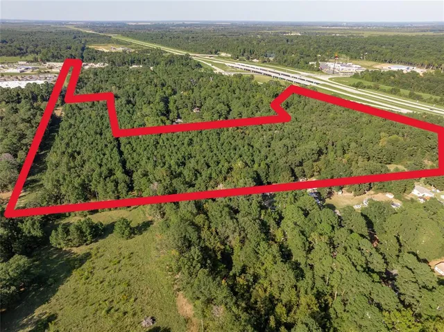 an aerial view of residential houses with outdoor space and trees