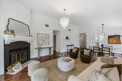 a view of a dining room with furniture a fireplace and wooden floor