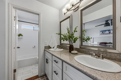 a bathroom with a granite countertop sink and a mirror