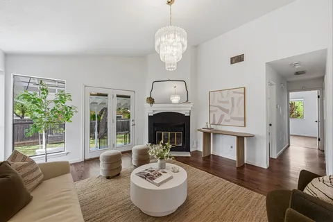 a living room with furniture a fireplace and a large mirror
