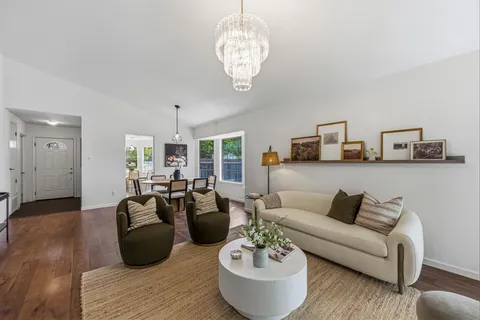 a living room with furniture and a chandelier