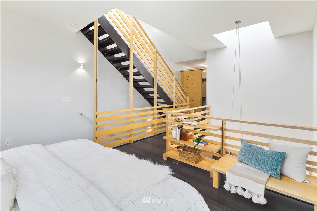1623 14th Avenue, Unit E Seattle, WA 98122 - Photo 23 of 40 a bedroom with a bed and wooden floor
