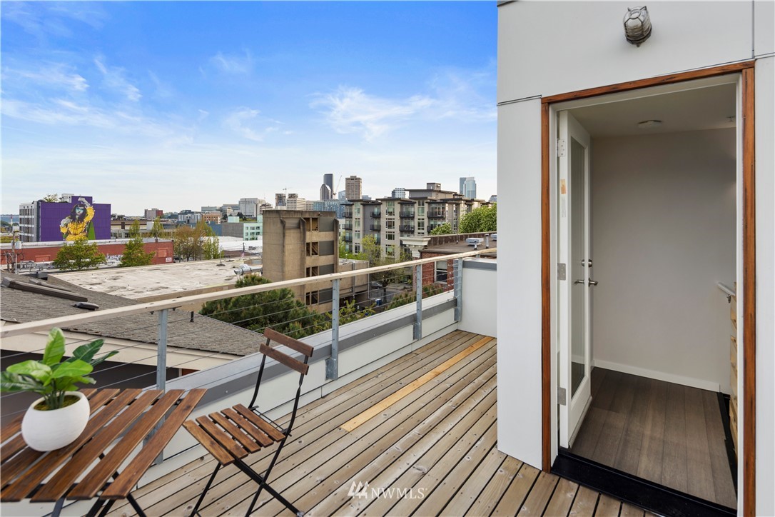 1623 14th Avenue, Unit E Seattle, WA 98122 - Photo 30 of 40 a view of a balcony with chairs and wooden floor