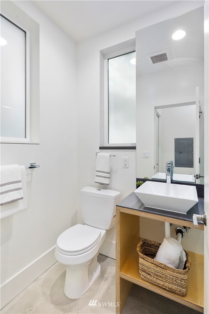 1623 14th Avenue, Unit E Seattle, WA 98122 - Photo 7 of 40 a bathroom with a toilet sink vanity and mirror