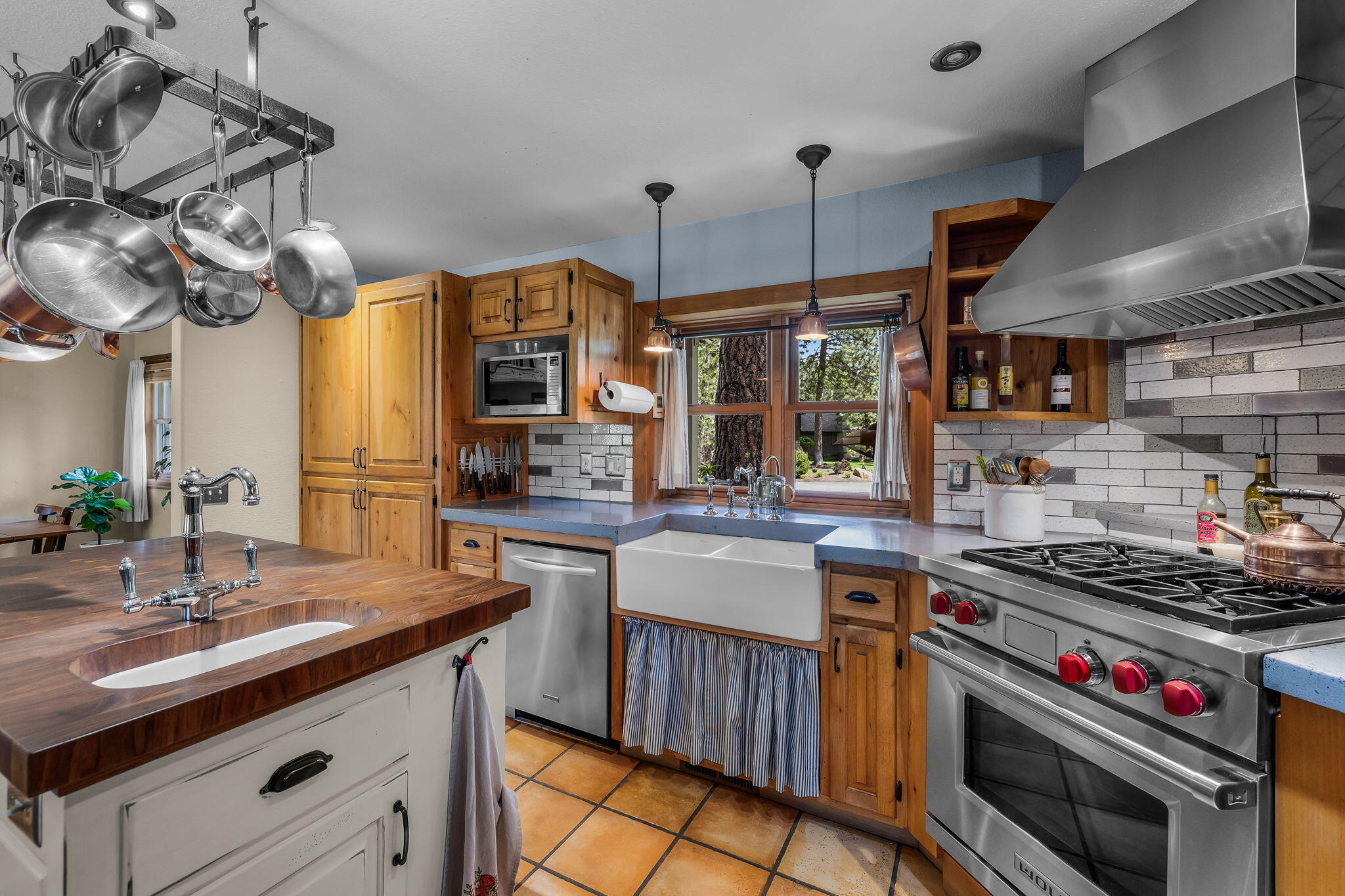 60779 Currant Way Bend, OR 97702 - Photo 16 of 63 a kitchen with stainless steel appliances a stove a sink and a wooden cabinets