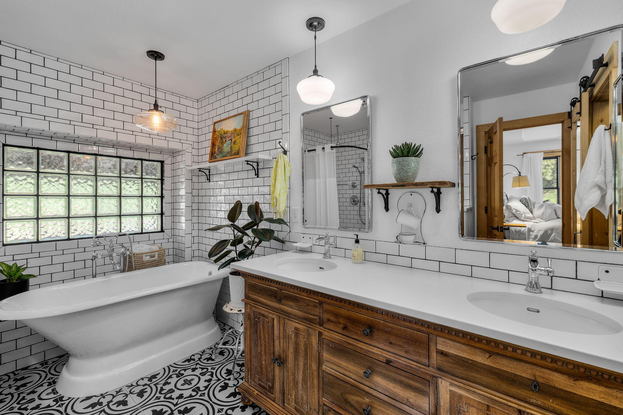 60779 Currant Way Bend, OR 97702 - Photo 24 of 63 a bathroom with a double vanity sink a mirror and a bathtub