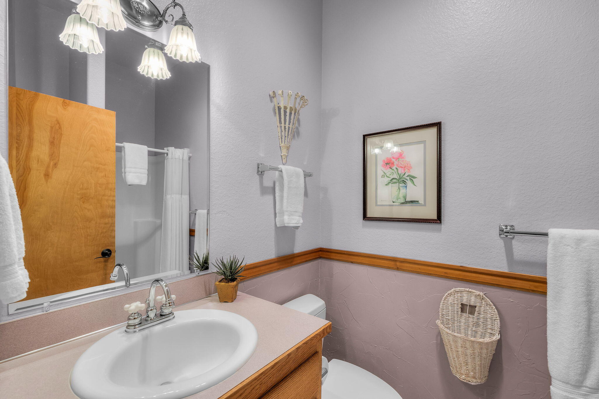 60779 Currant Way Bend, OR 97702 - Photo 44 of 63 a bathroom with a sink a mirror and a painting on the wall