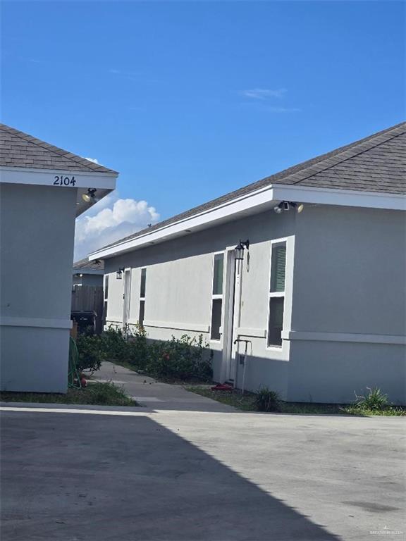 2104 Stauffers Street Weslaco, TX 78596 - Photo 2 of 12 View of exterior entry with stucco siding and a shingled roof