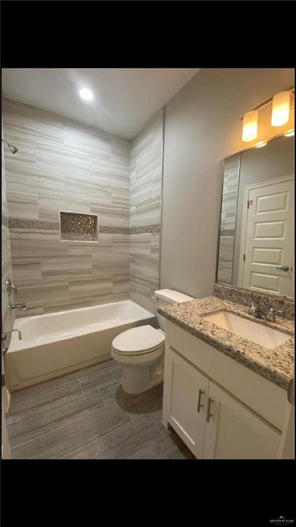 2104 Stauffers Street Weslaco, TX 78596 - Photo 7 of 12 Full bath with shower / bathtub combination, vanity, and wood finish floors