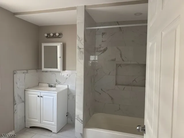 a bathroom with a shower a mirror and a sink