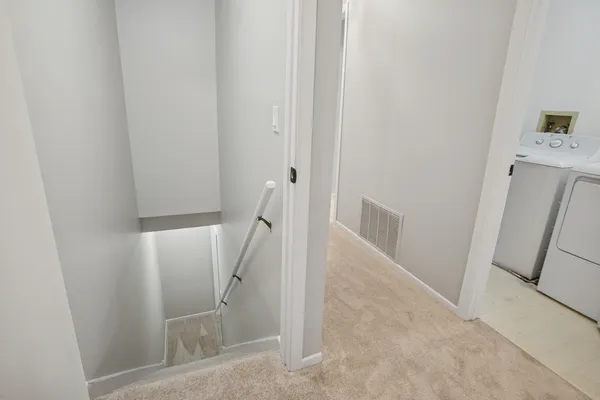 a view of a hallway to rooms and stairs