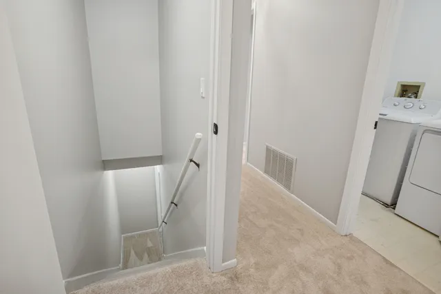 a view of a hallway to rooms and stairs