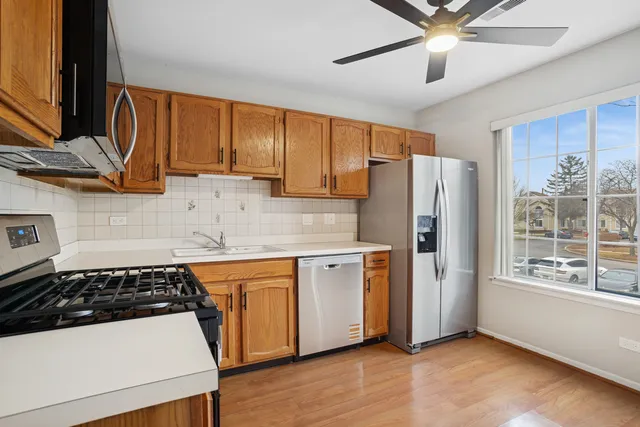 a kitchen with stainless steel appliances granite countertop a stove a sink and a microwave
