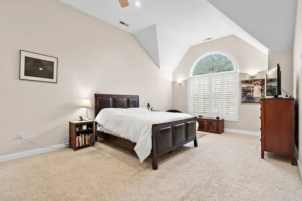 a spacious bedroom with a bed and wooden floor