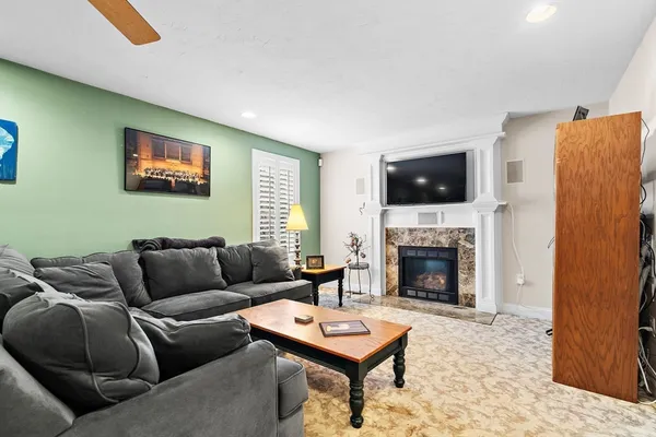 a living room with furniture a flat screen tv and a fireplace