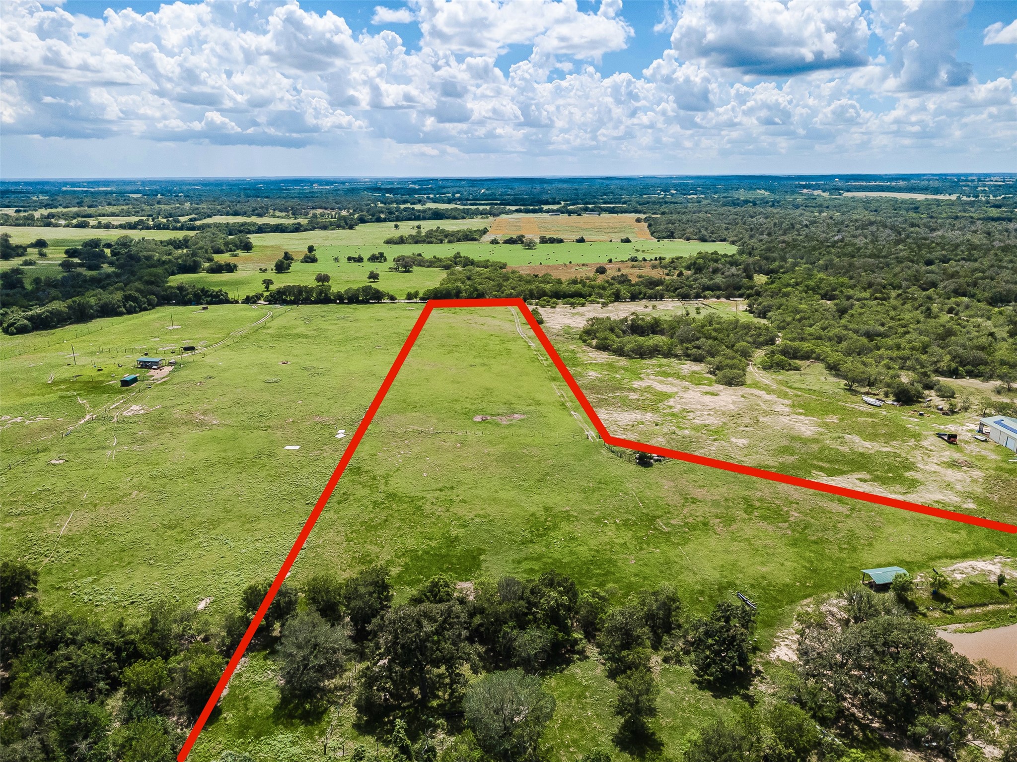 3109 Tenney Creek Road Dale, TX 78616 - Photo 13 of 23 Vast, open acreage awaits your vision, bordered by natural tree lines and a tranquil pond.