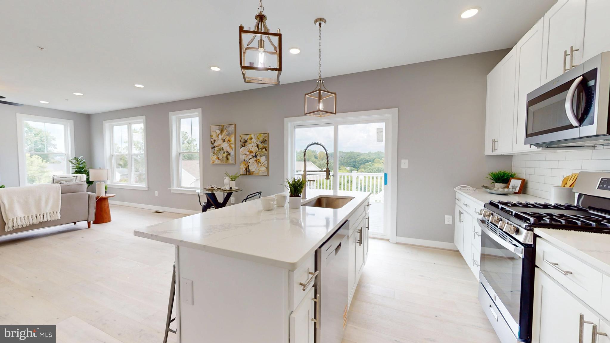 6516 Golden Ring Road Rosedale, MD 21237 - Photo 11 of 32 a kitchen with stainless steel appliances a sink a stove a refrigerator cabinets and living room view