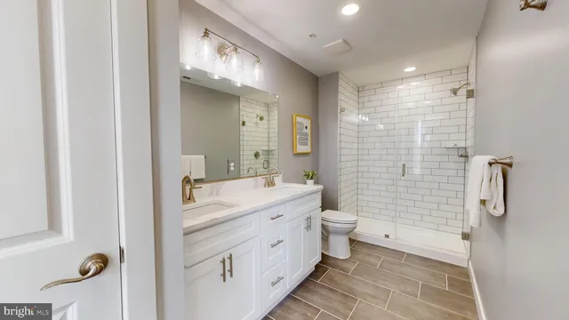 a bathroom with a double vanity sink toilet and shower