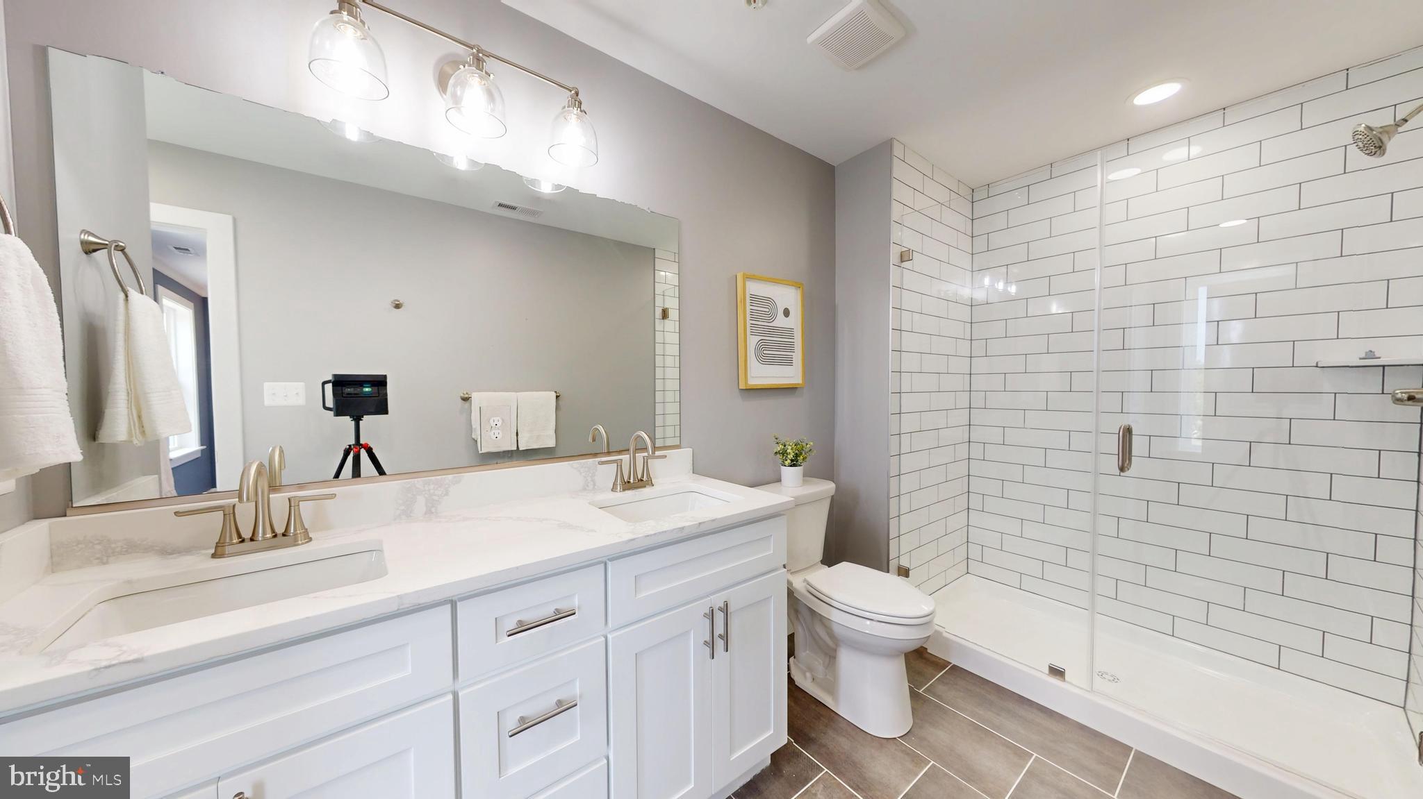 6516 Golden Ring Road Rosedale, MD 21237 - Photo 15 of 32 a bathroom with a double vanity sink toilet and shower