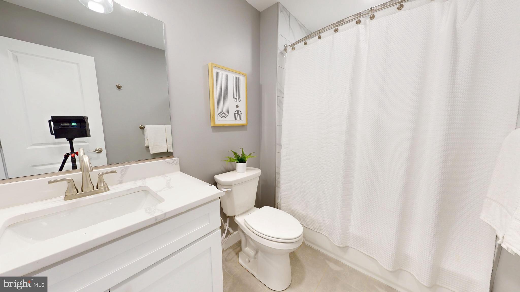 6516 Golden Ring Road Rosedale, MD 21237 - Photo 18 of 32 a bathroom with a sink a toilet and shower curtain