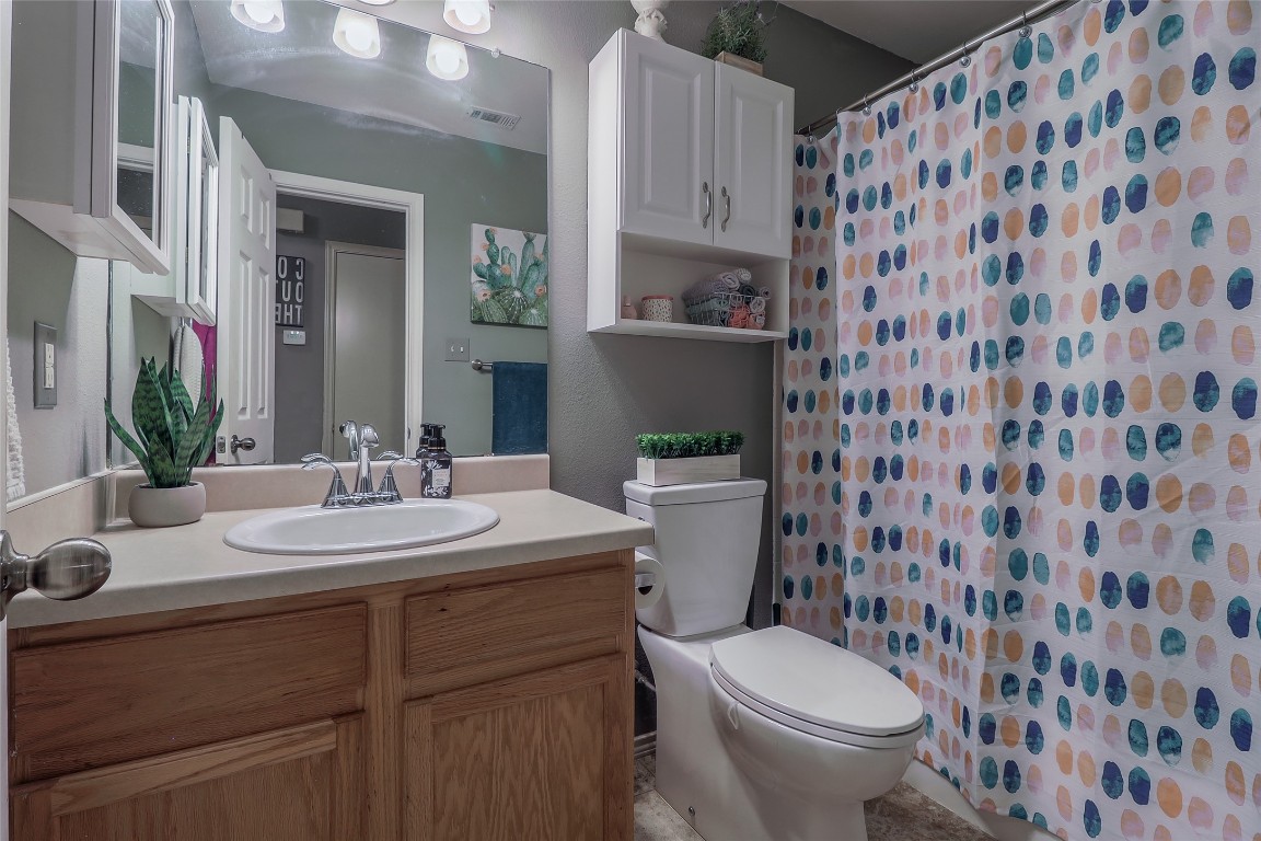 1705 Friars Tale Lane Austin, TX 78748 - Photo 20 of 29 a bathroom with a granite countertop toilet a sink and a mirror