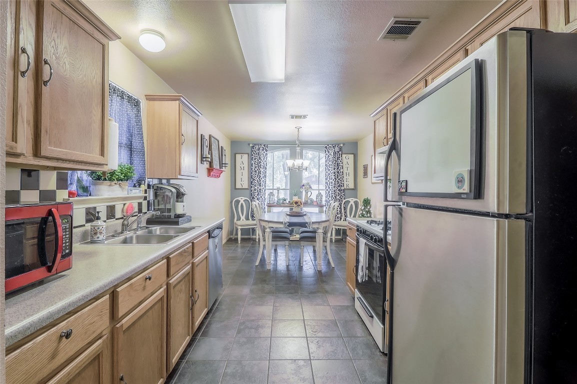 1705 Friars Tale Lane Austin, TX 78748 - Photo 8 of 29 a kitchen with a refrigerator and a sink