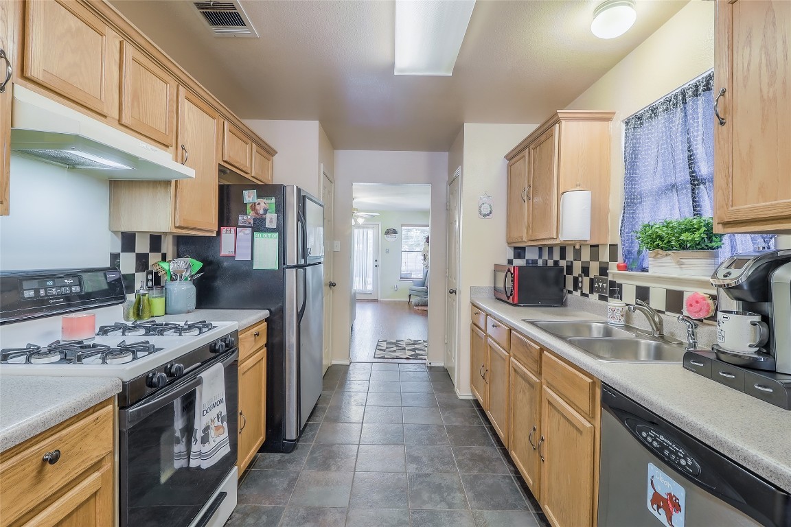 1705 Friars Tale Lane Austin, TX 78748 - Photo 10 of 29 a kitchen with stainless steel appliances granite countertop a lot of counter space and wooden floors