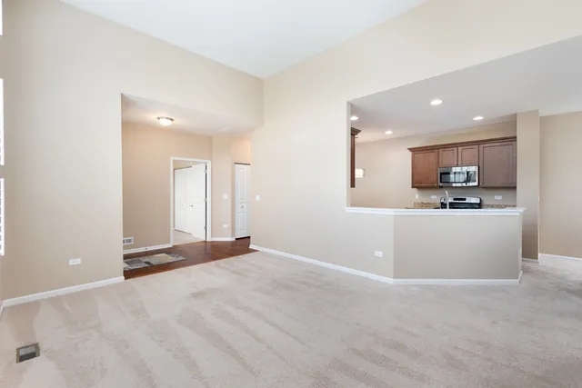 a view of a kitchen with refrigerator and white cabinets