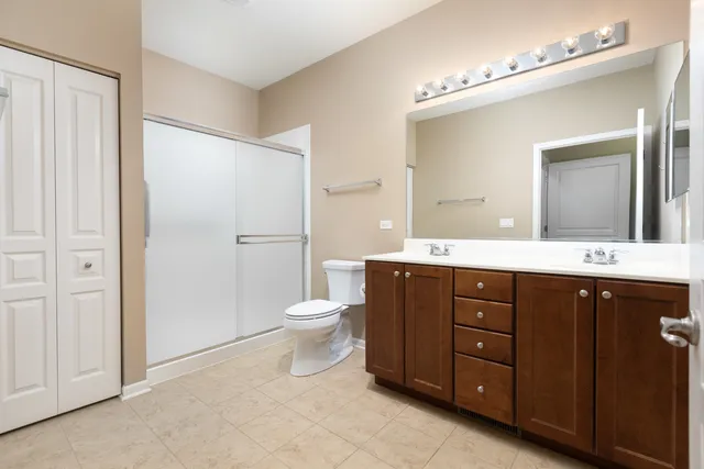 a bathroom with a toilet a sink a mirror and a shower