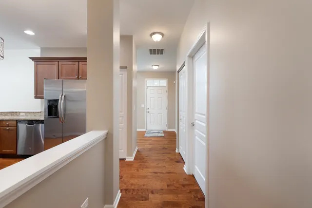 a view of a hallway with wooden floor and staircase