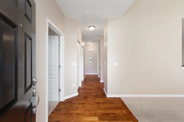 a view of a hallway with a livingroom and a window