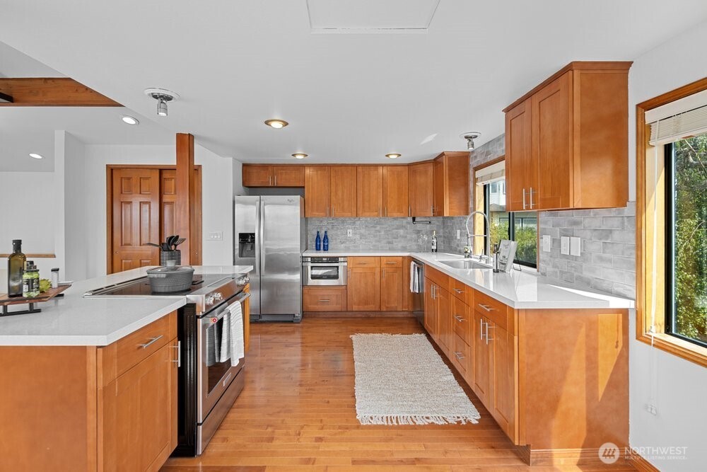 902 7th Avenue South Edmonds, WA 98020 - Photo 11 of 31 a kitchen with stainless steel appliances granite countertop a stove a sink dishwasher and a refrigerator