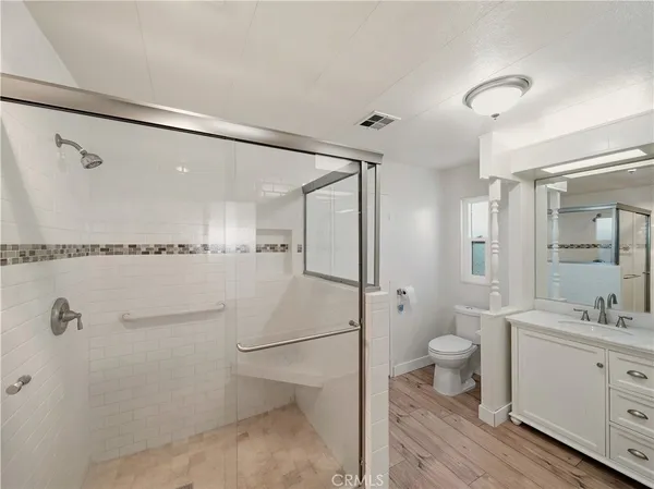 a bathroom with a double vanity sink toilet mirror and shower
