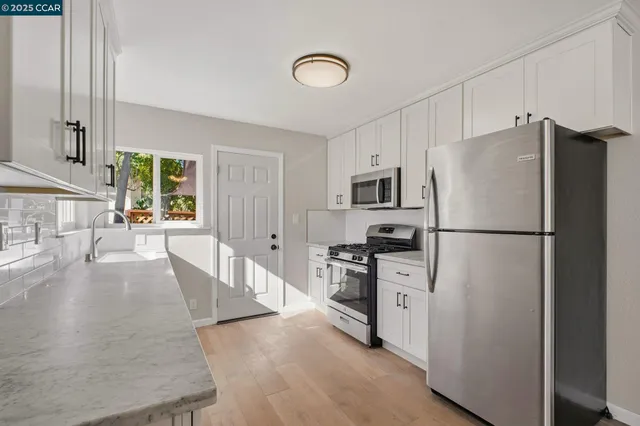 a kitchen with stainless steel appliances granite countertop a refrigerator stove microwave and sink