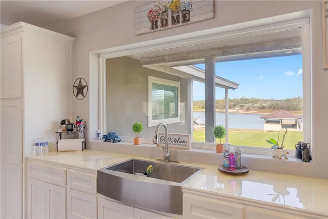 a kitchen counter with sink and view of living room