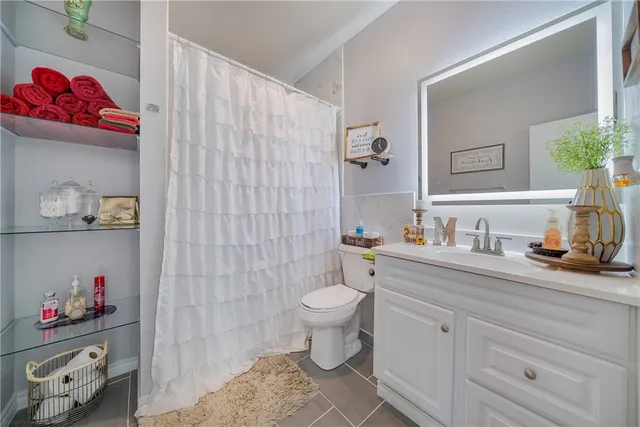 a bathroom with a sink a toilet and a mirror