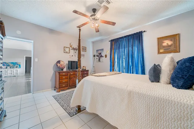 a bedroom with a large bed and a chandelier