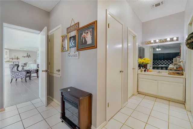 a room with a refrigerator and white cabinets