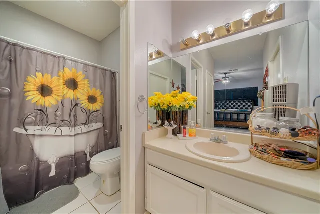 a bathroom with a sink a toilet and shower curtain