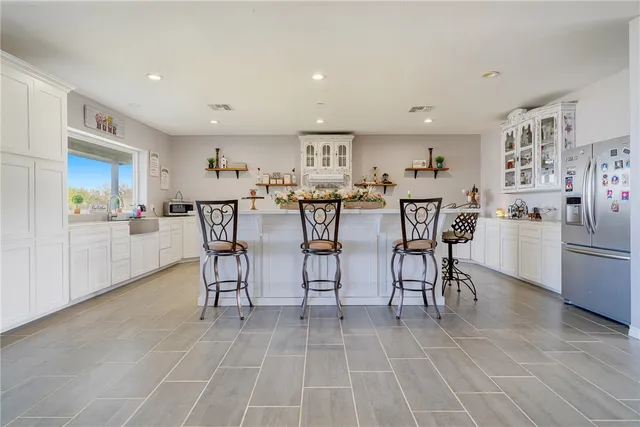 a view of kitchen with refrigerator stove dining table and chairs
