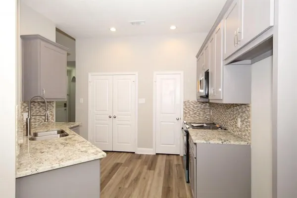 a kitchen with kitchen island granite countertop a sink stove and refrigerator