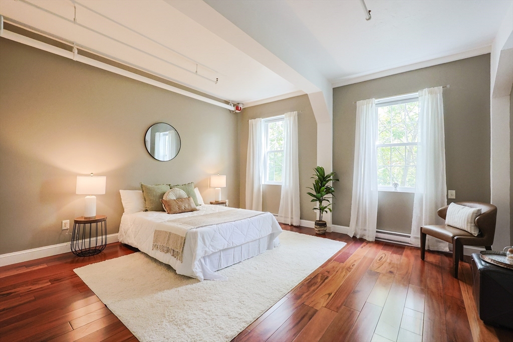 148 Bernon Street, Unit 19 Woonsocket, RI 02895 - Photo 11 of 20 a bedroom with a large bed and a wooden floor