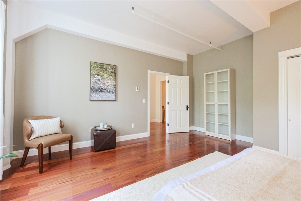 148 Bernon Street, Unit 19 Woonsocket, RI 02895 - Photo 12 of 20 a bedroom with furniture and a wooden floor