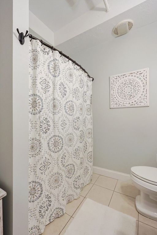 148 Bernon Street, Unit 19 Woonsocket, RI 02895 - Photo 13 of 20 a bathroom with a toilet and a shower curtain
