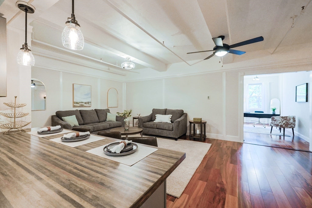 148 Bernon Street, Unit 19 Woonsocket, RI 02895 - Photo 2 of 20 a living room with furniture a wooden floor and a chandelier